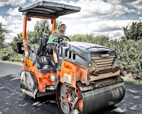Baustellenfotografie eines Arbeiters auf einer Walze während Straßenbauarbeiten bei Apelnstedt im Landkreis Wolfenbüttel.
